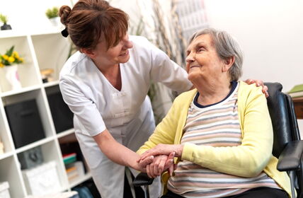 Ältere Frau wird von Pflegefachkraft betreut und unterstützt